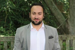 picture of a man sitting on bench in a blazer