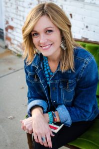 woman in jean jacket sitting on a bench
