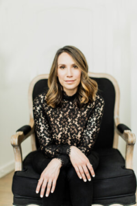 woman in a lace shirt sitting in a chair