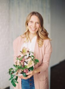 headshot of a woman holding a bouquet of flowers