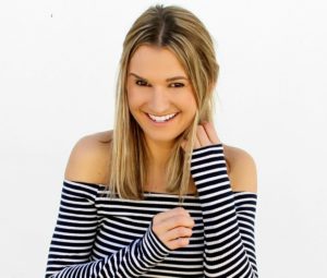 headshot of smiling woman in a striped shirt